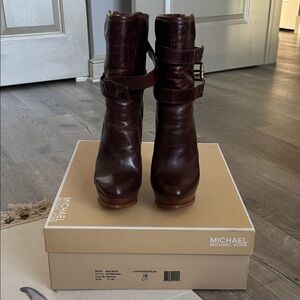 Michael Kors brown leather Mae platform ankle boots with gold buckles.